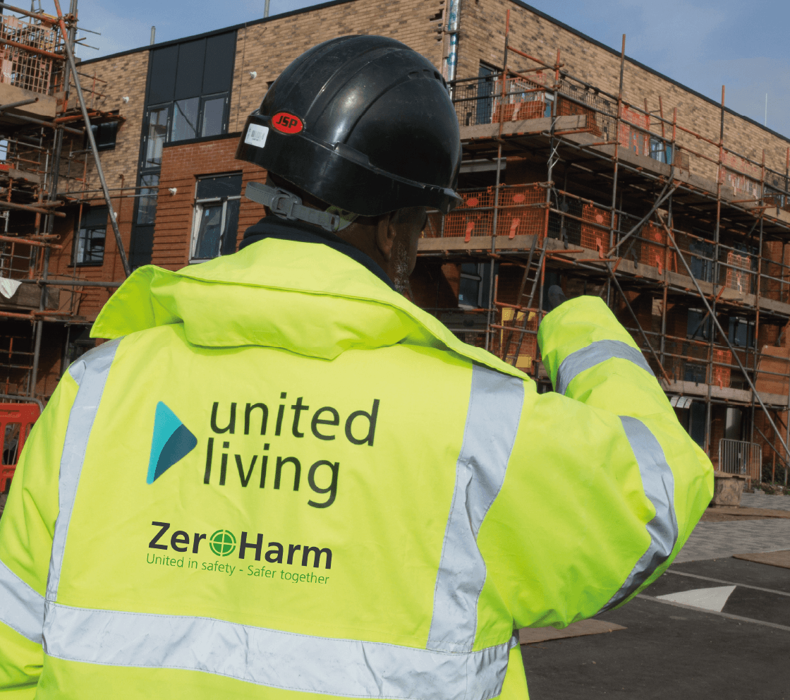 construction worker standing in front of newly constructed multi-family building