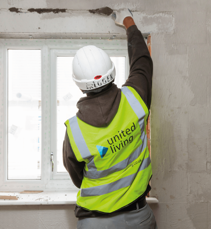 employee fixing wall by a window of residential home