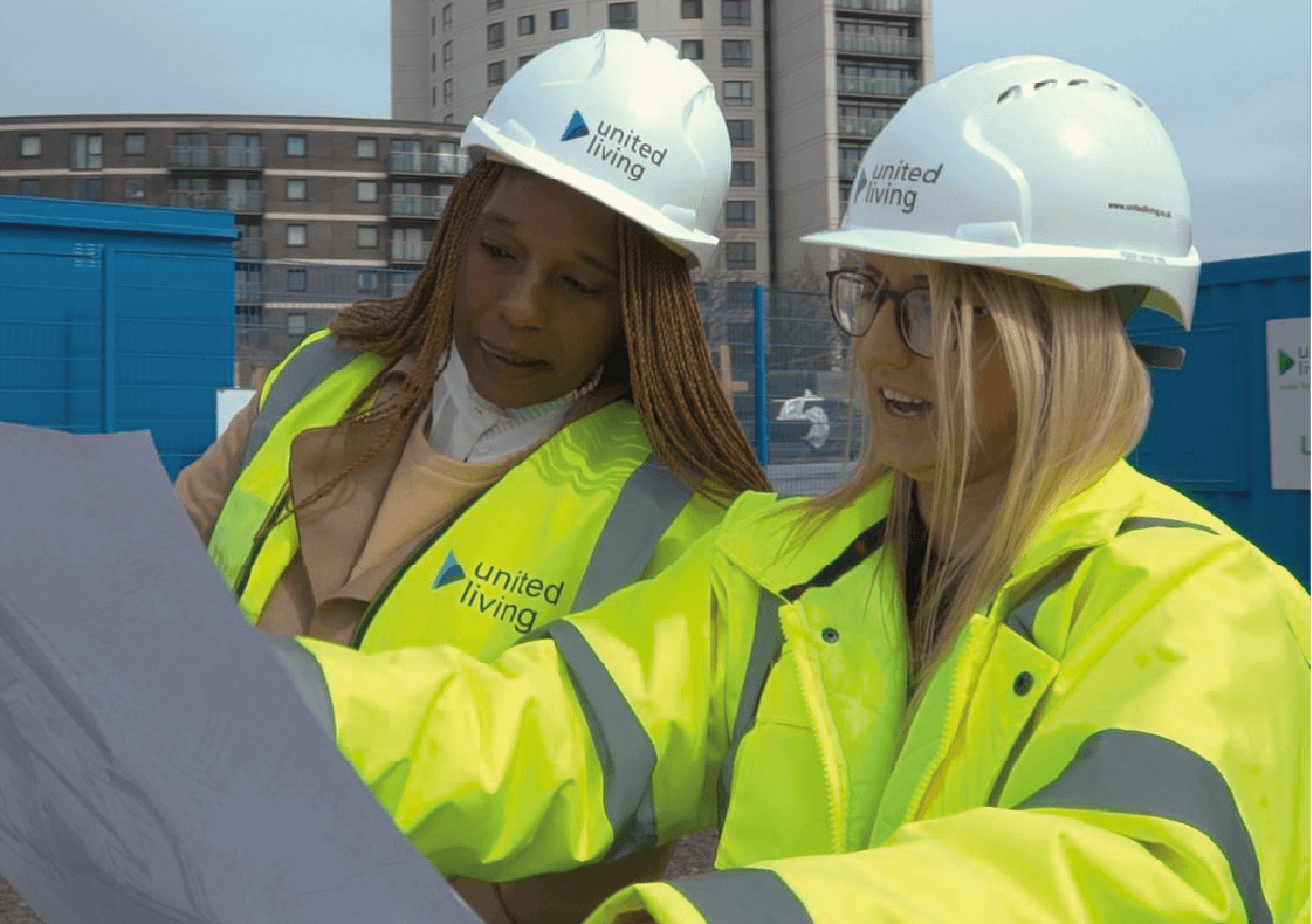 two construction workers on site reviewing plans