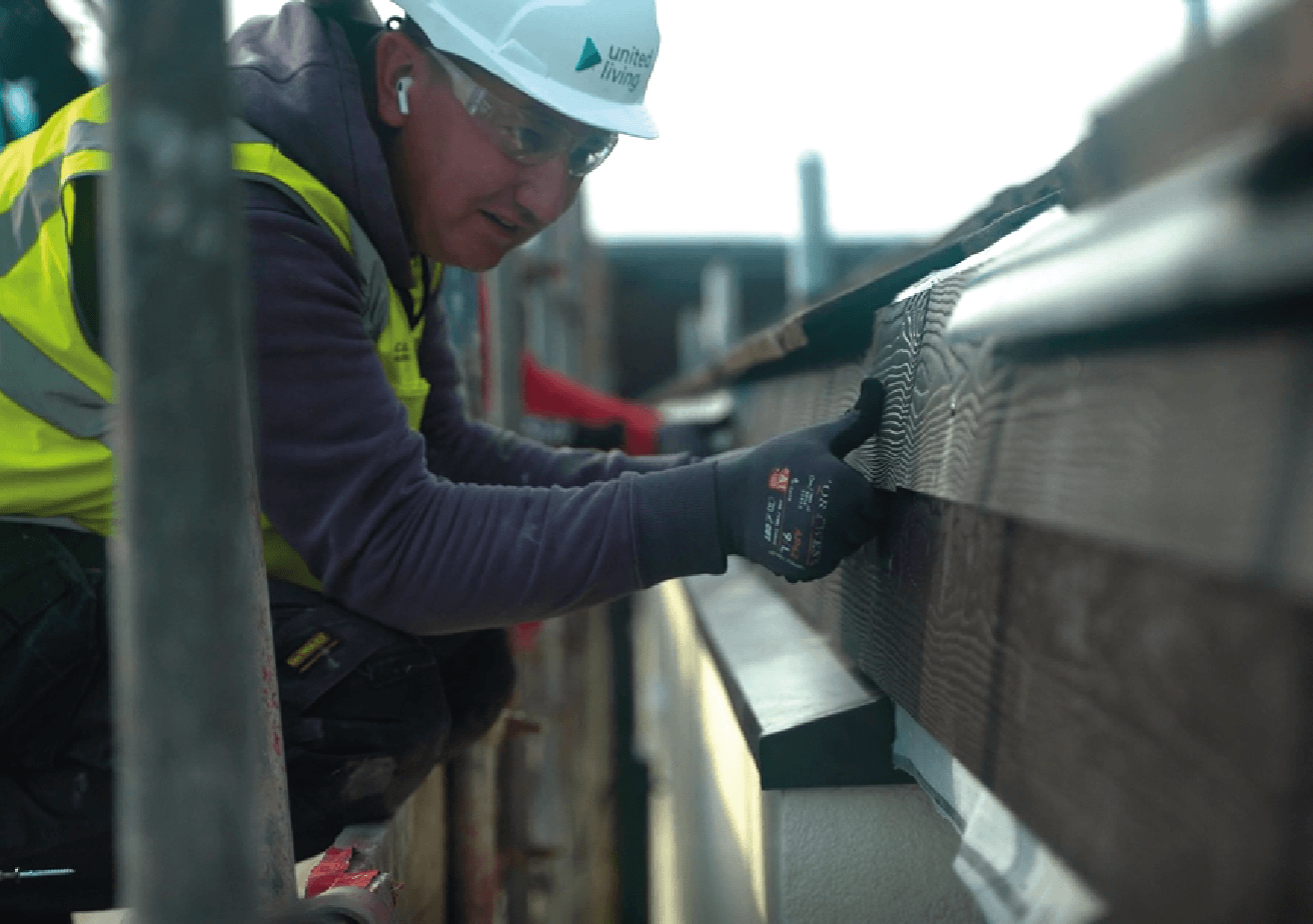 employee fitting external cladding to home