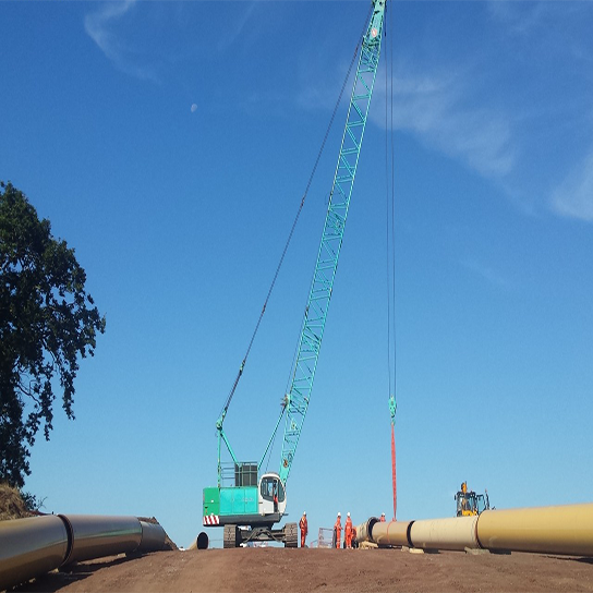 Crane lifting large pipes