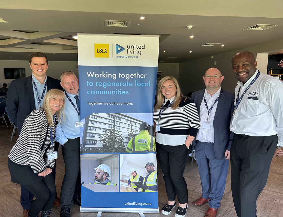united living employees posing with pull up banner