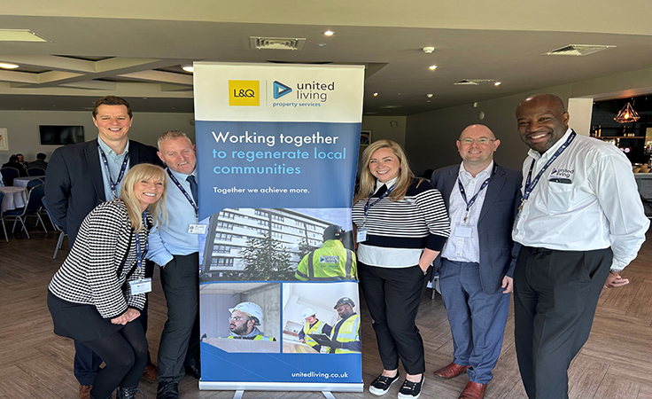 united living employees posing with pull up banner
