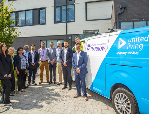 group of people stood in front of building and branded van